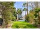 Landscaped backyard featuring a well-maintained lawn, a pool, and towering palm trees at 904 Middle St, Sullivans Island, SC 29482