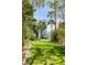 Green lawn and pool area of the backyard, surrounded by various plants and palm trees at 904 Middle St, Sullivans Island, SC 29482