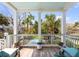 Inviting balcony with blue cushions overlooks a tranquil pool surrounded by lush tropical landscaping at 904 Middle St, Sullivans Island, SC 29482