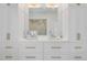 Elegant bathroom vanity featuring double sinks, white cabinets, and stylish gold hardware at 904 Middle St, Sullivans Island, SC 29482