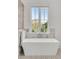 Bathroom with a freestanding soaking tub and marble tile detail with a view of outside at 904 Middle St, Sullivans Island, SC 29482