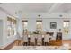 Bright dining room features hardwood floors, white walls and trim, and multiple windows with woven shades at 904 Middle St, Sullivans Island, SC 29482