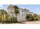 Beautiful home exterior with a clean white palette, palm trees, and a two-car garage at 904 Middle St, Sullivans Island, SC 29482