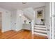 Inviting foyer with hardwood floors, white staircase, stylish dresser, and charming wall art at 904 Middle St, Sullivans Island, SC 29482