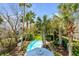 Aerial view of pool with clear blue water surrounded by palm trees and a lush green yard at 904 Middle St, Sullivans Island, SC 29482