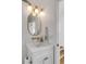 Stylish powder room with gold pineapple lights, marble countertop, and decorative mirror at 904 Middle St, Sullivans Island, SC 29482