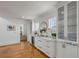 Wet bar area has marble countertops, white cabinets, wine fridge, and glass shelving at 904 Middle St, Sullivans Island, SC 29482