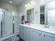 Bathroom with double sink vanity, large mirror, and glass shower, offering a clean, modern aesthetic at 9723 Flooded Field Dr, Ladson, SC 29456