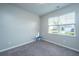 A bedroom featuring neutral walls and carpeted flooring, complemented by natural light from the window at 9723 Flooded Field Dr, Ladson, SC 29456
