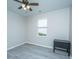 A bedroom with light gray laminate flooring, a ceiling fan, and a dark cabinet under a window at 9723 Flooded Field Dr, Ladson, SC 29456