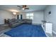 Open-concept living area featuring plush blue rug, ceiling fan, and adjacent dining space at 9723 Flooded Field Dr, Ladson, SC 29456