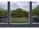 Framed view from a porch of a green lawn and a large tree in the center of a courtyard area at 102 Dandelion St, Summerville, SC 29483