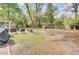 Large backyard with mature trees, seating area, grill, and playhouse at 103 Arbor Rd, Summerville, SC 29485