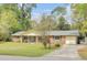 Charming single-story brick home with a well-manicured lawn, inviting porch swing and an attached garage at 103 Arbor Rd, Summerville, SC 29485