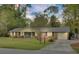 Charming single-story brick home with a well-manicured lawn, inviting porch swing and an attached garage at 103 Arbor Rd, Summerville, SC 29485