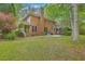 Expansive backyard featuring a brick home, patio, and mature trees at 104 Huckleberry Ln, Summerville, SC 29485