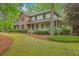 Charming two-story home with brick accents, inviting porch, and mature landscaping in a wooded setting at 104 Huckleberry Ln, Summerville, SC 29485
