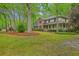 Stately brick and siding home with a lush, green lawn and mature trees providing shade and curb appeal at 104 Huckleberry Ln, Summerville, SC 29485