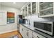 Updated kitchen features modern appliances, glass door cabinets, and herringbone tile backsplash at 1056 Wharf Indigo Pl, Mount Pleasant, SC 29464