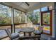 Cozy screened-in porch featuring wood furnishings, comfortable seating, and a ceiling fan for breezy relaxation at 1056 Wharf Indigo Pl, Mount Pleasant, SC 29464