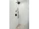 Modern bathroom shower featuring white subway tile, black fixtures, and mosaic tile flooring at 1056 Wharf Indigo Pl, Mount Pleasant, SC 29464