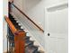 Carpeted stairs with wood banister, newel post and white door at 1056 Wharf Indigo Pl, Mount Pleasant, SC 29464