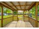 Covered wooden back porch overlooking a green backyard surrounded by mature trees at 106 Dunmow Dr, Summerville, SC 29485