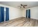 Spacious bedroom with wood flooring, a ceiling fan, and natural light from two windows with blue curtains at 106 Dunmow Dr, Summerville, SC 29485