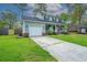 Two-story home featuring an attached garage and a spacious front lawn on a sunny day at 106 Dunmow Dr, Summerville, SC 29485