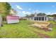 Large backyard with a shed, garden beds, well-kept grass, and partial view of the rear of the house at 1302 Camden Xing, Hanahan, SC 29410