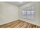 Neutral bedroom offers wood-look flooring and a window with blinds at 1302 Camden Xing, Hanahan, SC 29410