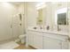 Well-lit bathroom featuring double sinks with white cabinets and a glass-enclosed shower at 135 Pier View # 305, Charleston, SC 29492
