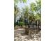 Community patio with stone outdoor grill, lush landscaping, and umbrella-shaded lounge chairs at 135 Pier View # 305, Charleston, SC 29492