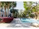 Community pool surrounded by palm trees, lounge chairs, lush landscaping, and blue umbrellas at 135 Pier View # 305, Charleston, SC 29492