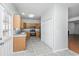 Spacious kitchen featuring cabinets, appliances, a side door, tile flooring, and view to front living room at 137 St Phillips Row, Summerville, SC 29485