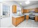 Kitchen area featuring wooden cabinets, stainless appliances, a backyard door, and tile flooring at 137 St Phillips Row, Summerville, SC 29485