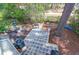 Aerial view of a patio with chairs, a grill, and a bench in a wooded backyard at 14 Town Park Ln # B, Charleston, SC 29412