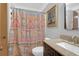 Well-lit bathroom with a vanity, granite counters, and a patterned shower curtain at 14 Town Park Ln # B, Charleston, SC 29412