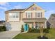 Charming two-story home boasts a well-manicured lawn, turquoise door and attached garage, offering curb appeal at 1529 Fishbone Dr, Johns Island, SC 29455