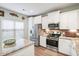 Modern kitchen with white cabinets, granite countertops, stainless steel appliances, and tile backsplash offers functionality at 1529 Fishbone Dr, Johns Island, SC 29455