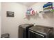 Laundry room featuring modern appliances, storage shelf, and a decorative laundry room sign at 1529 Fishbone Dr, Johns Island, SC 29455