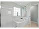Main bathroom with a glass enclosed shower, jacuzzi tub, and a large window at 1529 Fishbone Dr, Johns Island, SC 29455