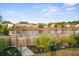 Backyard view of a serene pond surrounded by lush landscaping and neighborhood homes at 1529 Fishbone Dr, Johns Island, SC 29455