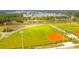 An aerial view of a baseball field and a pond surrounded by lush greenery, and nearby houses at 154 Calm Water Way, Summerville, SC 29486