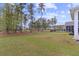 Wide backyard with grassy lawn, surrounded by mature trees at 154 Calm Water Way, Summerville, SC 29486
