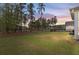 Expansive backyard with lush grass, mature trees, and views of neighboring homes at 154 Calm Water Way, Summerville, SC 29486