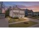 A charming two-story home features a welcoming front porch, a well-manicured lawn and a two car garage at 154 Calm Water Way, Summerville, SC 29486