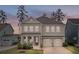 A beautiful two-story home has a charming front porch and a well-manicured lawn leading to the two car garage at 154 Calm Water Way, Summerville, SC 29486