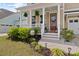 Inviting front porch featuring manicured shrubs, beautiful hanging plants, and decorative accents at 154 Calm Water Way, Summerville, SC 29486