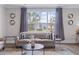 Bright living room featuring large windows, hardwood floors, and stylish neutral furniture at 154 Calm Water Way, Summerville, SC 29486